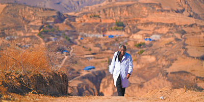 張尚保走在去鐵頭村張家灣自然村出診的路上。