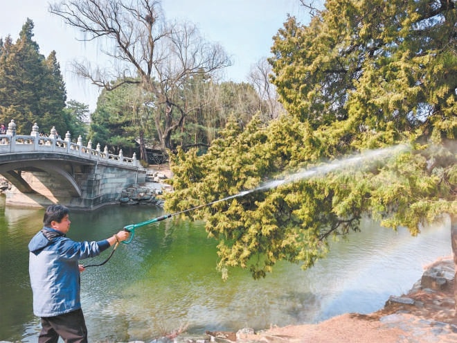 圖為工作人員用高壓水槍進(jìn)行濕化作業(yè)。