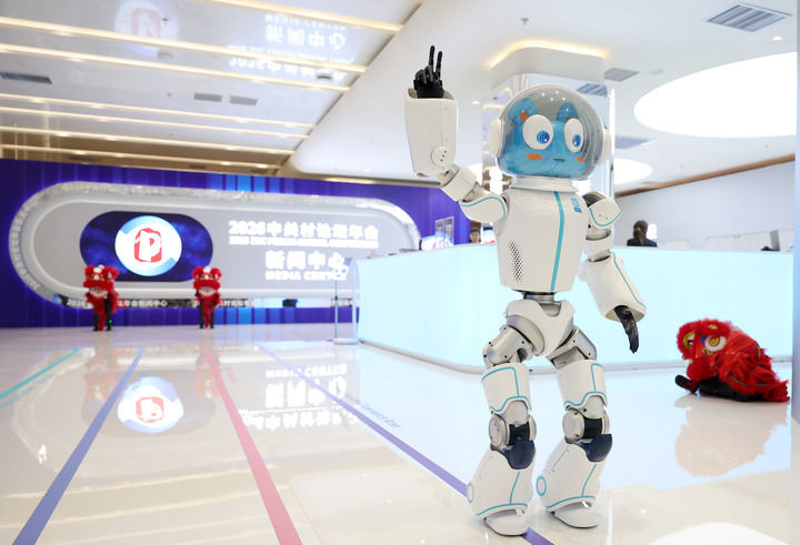 3月24日，在中關(guān)村論壇年會新聞中心內(nèi)，一臺機(jī)器人在向觀眾招手。