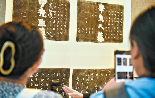 觀眾認(rèn)真觀看李大釗烈士和夫人墓碑拓片。