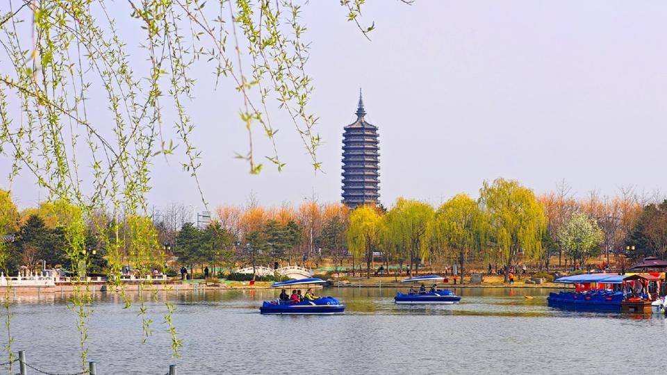 游人泛舟湖上，悠然自得。