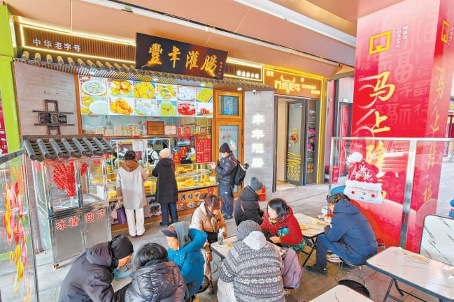 2月12日，在隆福寺豐年灌腸店鋪，市民游客品嘗北京特色小吃。