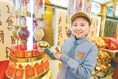 北京稻香村零號(hào)尋寶館店長(zhǎng)曹思源展示特色糕點(diǎn)盤(pán)紐糕和琵琶糕。