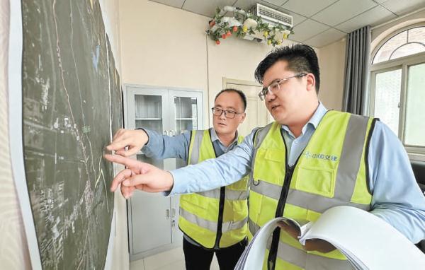 1月31日，劉太訓（右）和同事正在研究施工方案。