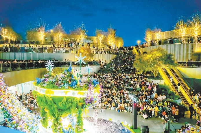 夜色下，顧客在萬(wàn)象匯觀(guān)看演出。（資料圖）