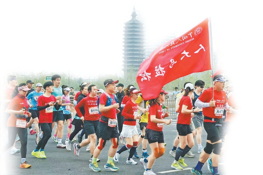 中國(guó)人民大學(xué)校友馬拉松跑團(tuán)經(jīng)過(guò)燃燈塔。