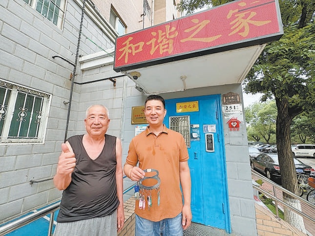 周治國（右）幫鄰居保管鑰匙。