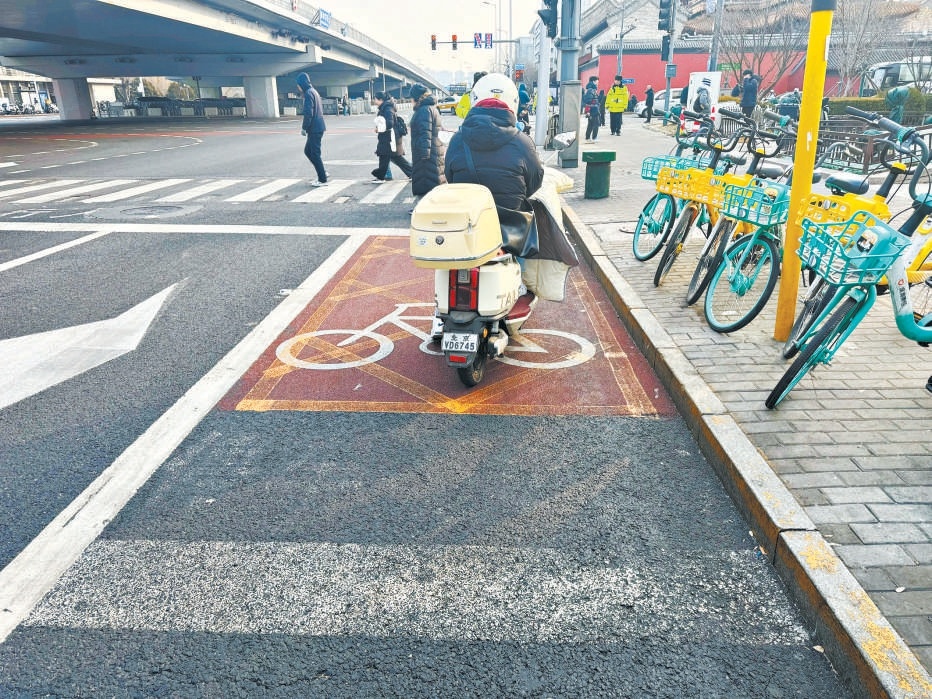 昨晨，雍和宮橋下路口，電動(dòng)自行車停到了禁停的黃色網(wǎng)格線里。